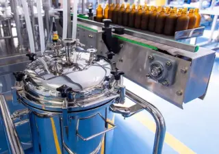 Упаковка жидкостных фармацевтических продуктов во флаконы, пузырьки с автоматической установкой капельниц и крышек. Нанесение этикеток